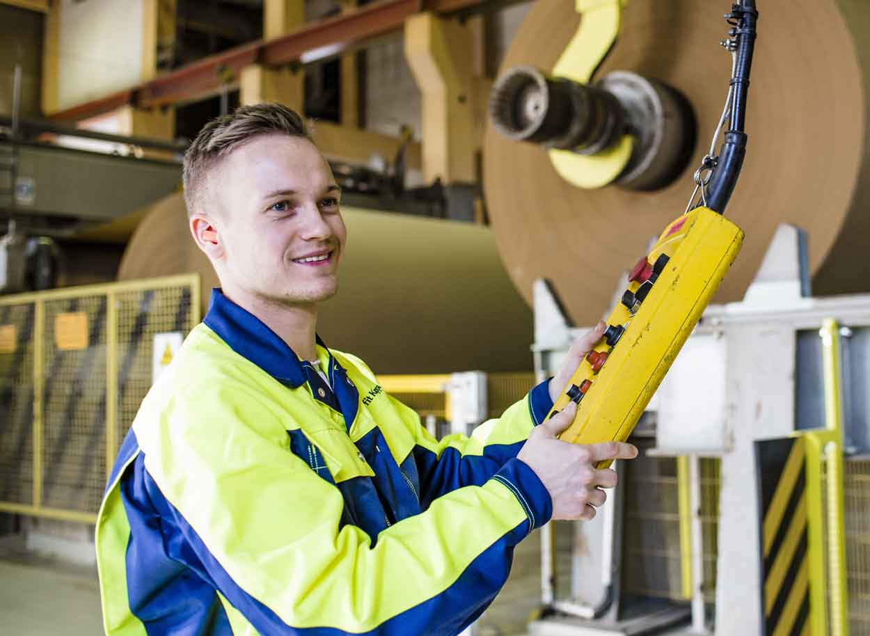 Un homme souriant tient à la main un boîtier pour contrôler les machines à l'usine 
